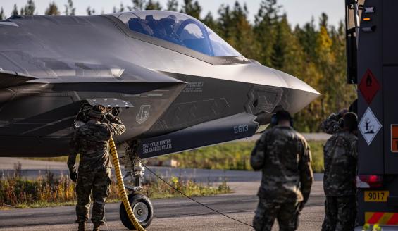 Maassa otettu lähikuva yhdysvaltalaisen F-35-hävittäjän keulasta. Yhdysvaltalaissotilaat tankkaavat hävittäjää Hosion varalaskupaikalla. Taustalla näkyy syksyistä suomalaista metsää.