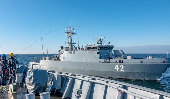 A mine countermeasures vessel Vahterpää sails next to another vessel at sea.