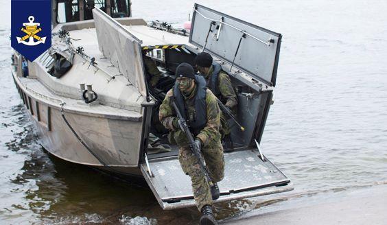 Varusmiehet poistuvat joukkojenkuljetusveneestä rantaan.