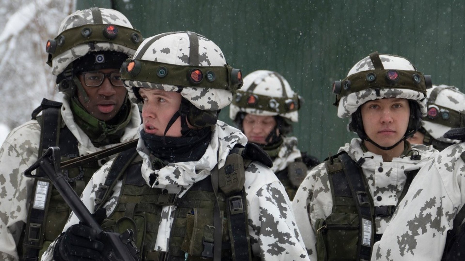 Kuvassa on varusmiehiä, joilla on yllään simulaattoriliivit, jotka koostuu kypärästä ja taisteluliiviin kiinnitettävistä prismoilla varustetuista valjaista.