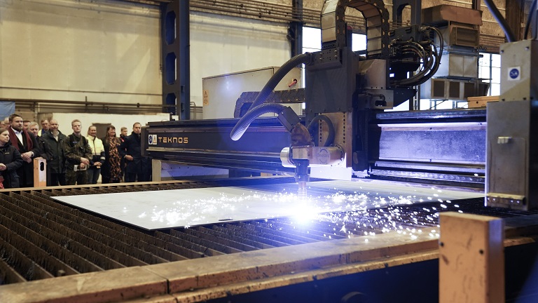 Machine cuts steel sheet.