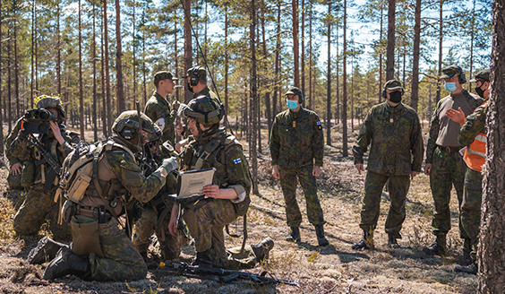 Porin prikaatin varusmiehiä metsässä harjoittelemassa. Harjoituksen johtaja Tuomas Tiilikainen seuraamassa toimintaa.